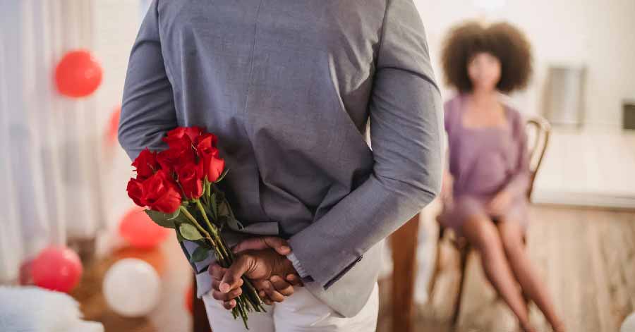 man about to surprise a woman with a bunch of roses