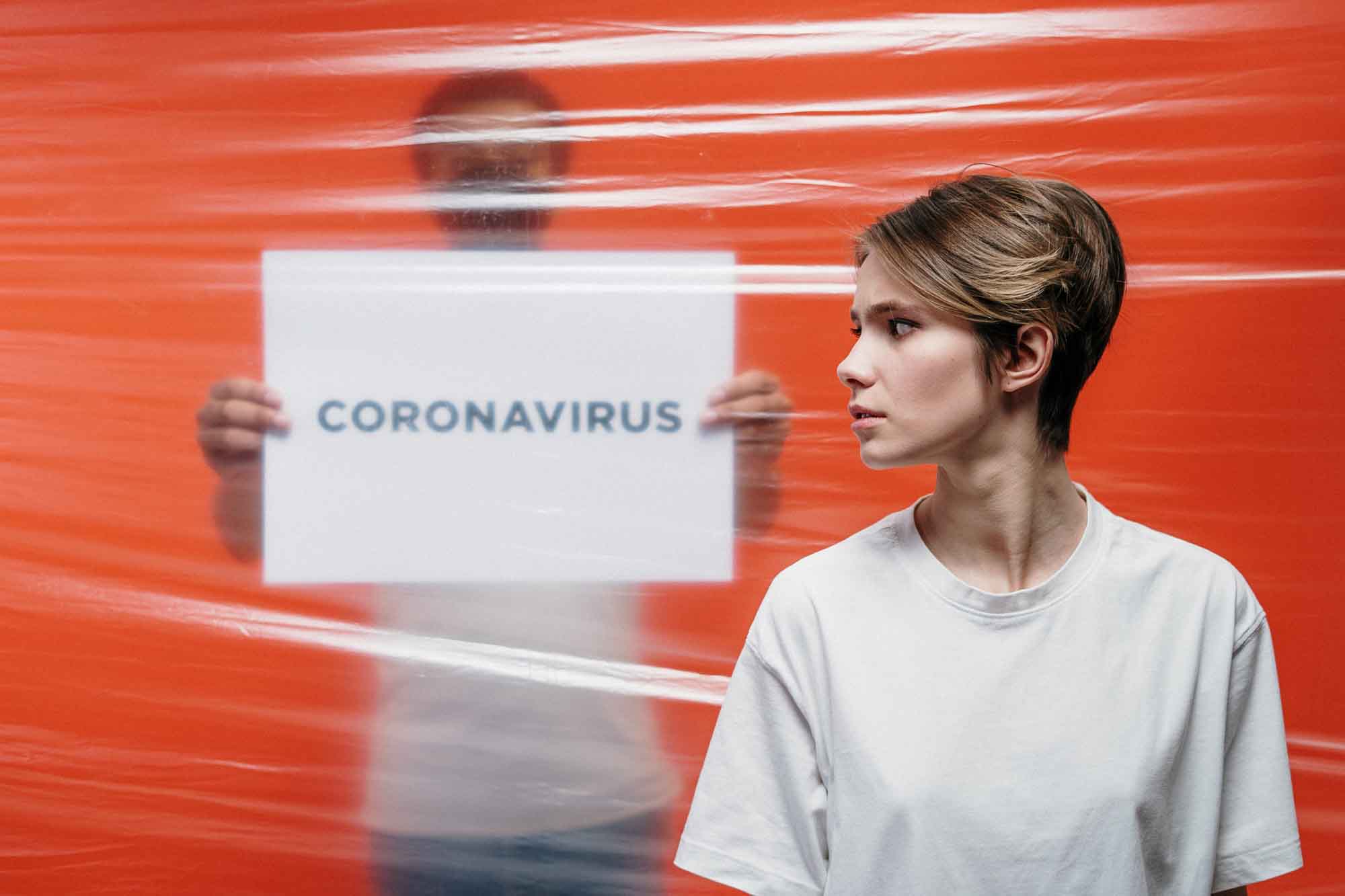 A photo of a lady with corona virus note behind her