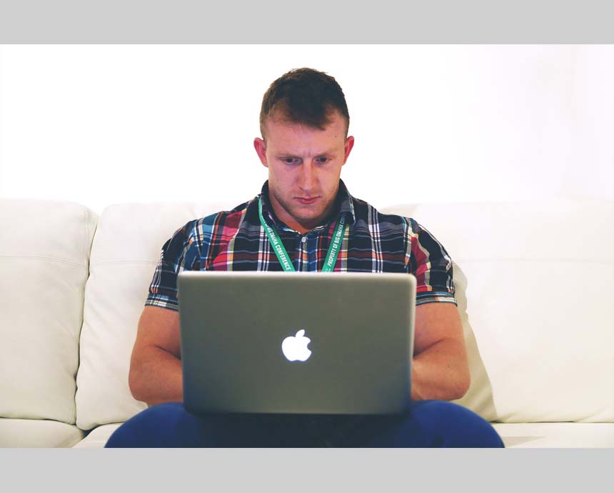 man with a suspicious face holding a laptop