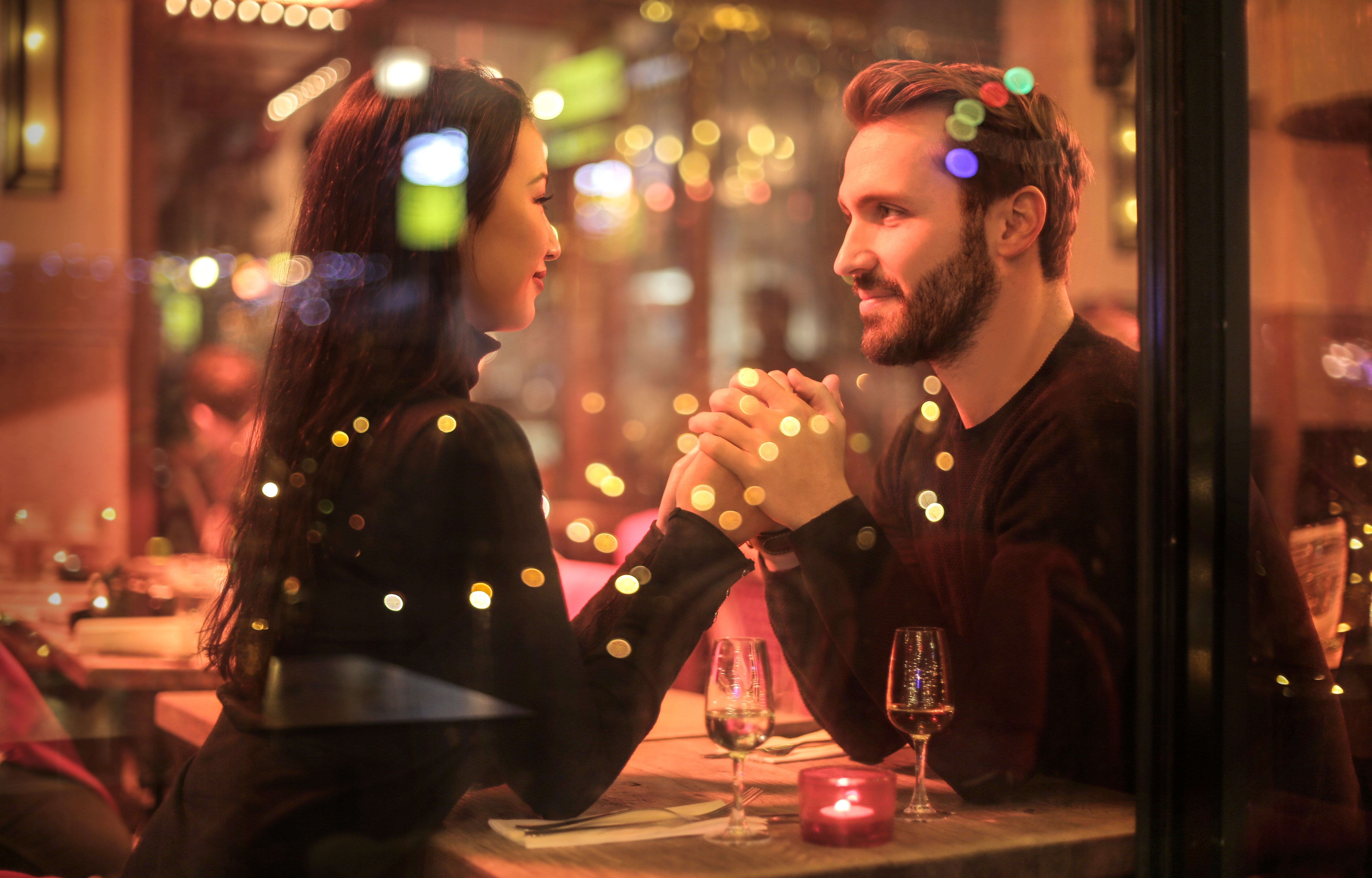 Man and woman holding hands in a restaurant